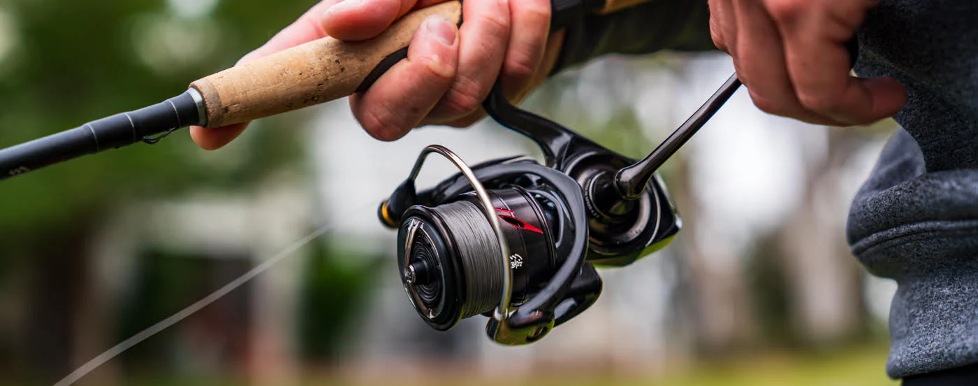 Катушка Daiwa на удилище в руках рыболова